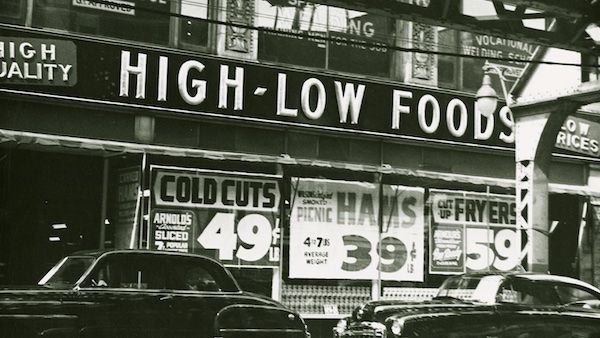 A black and white photo of the exterior of a grocery store